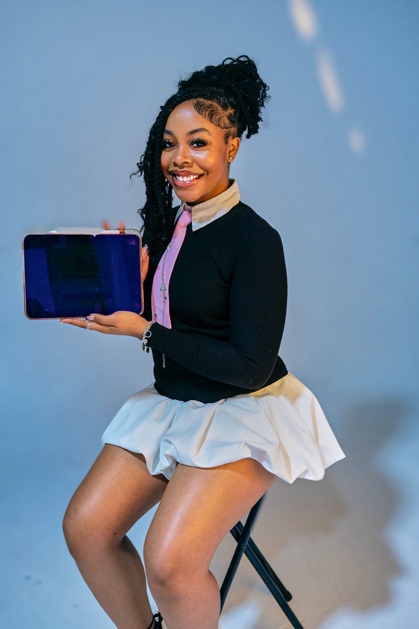 Seated portrait holding an open certificate case.